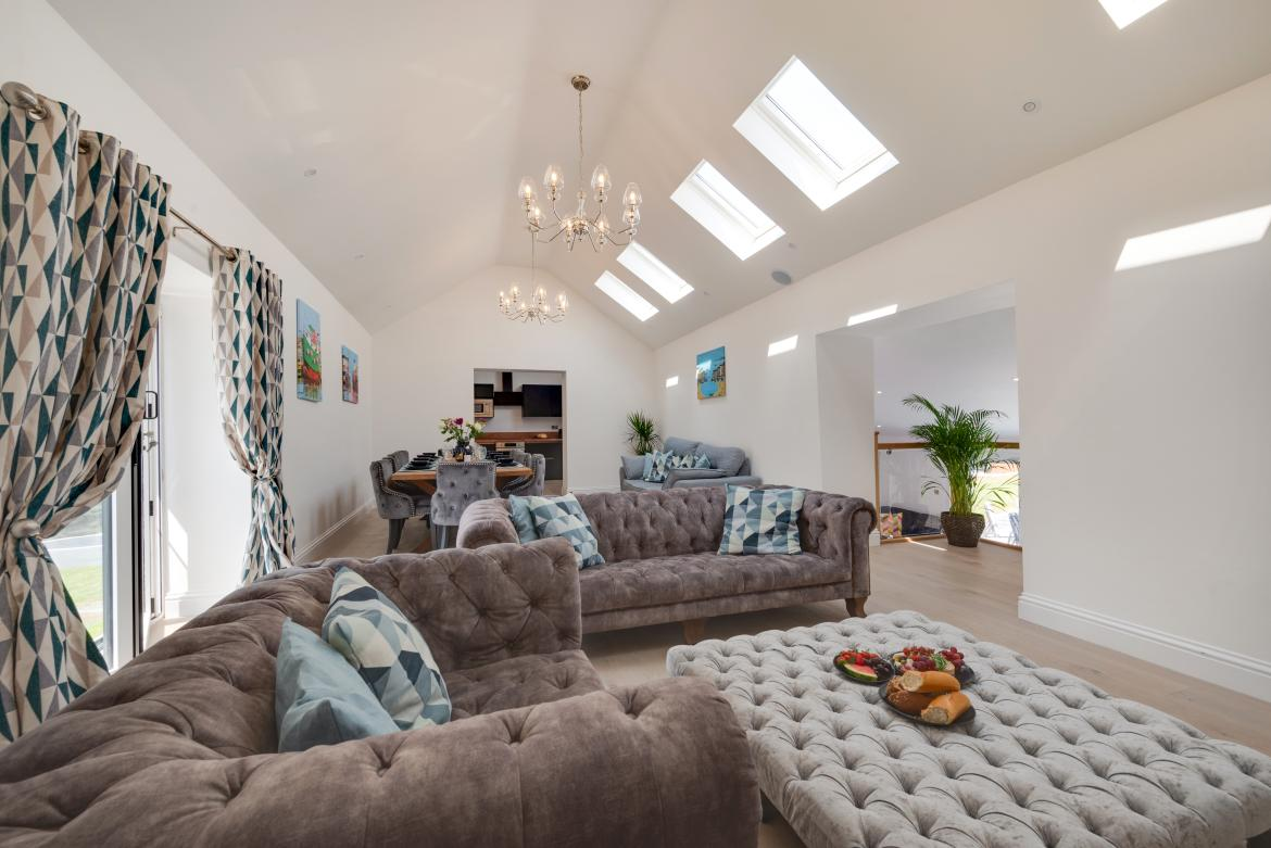 Open-plan lounge and dining space with rooflights at Bowjy