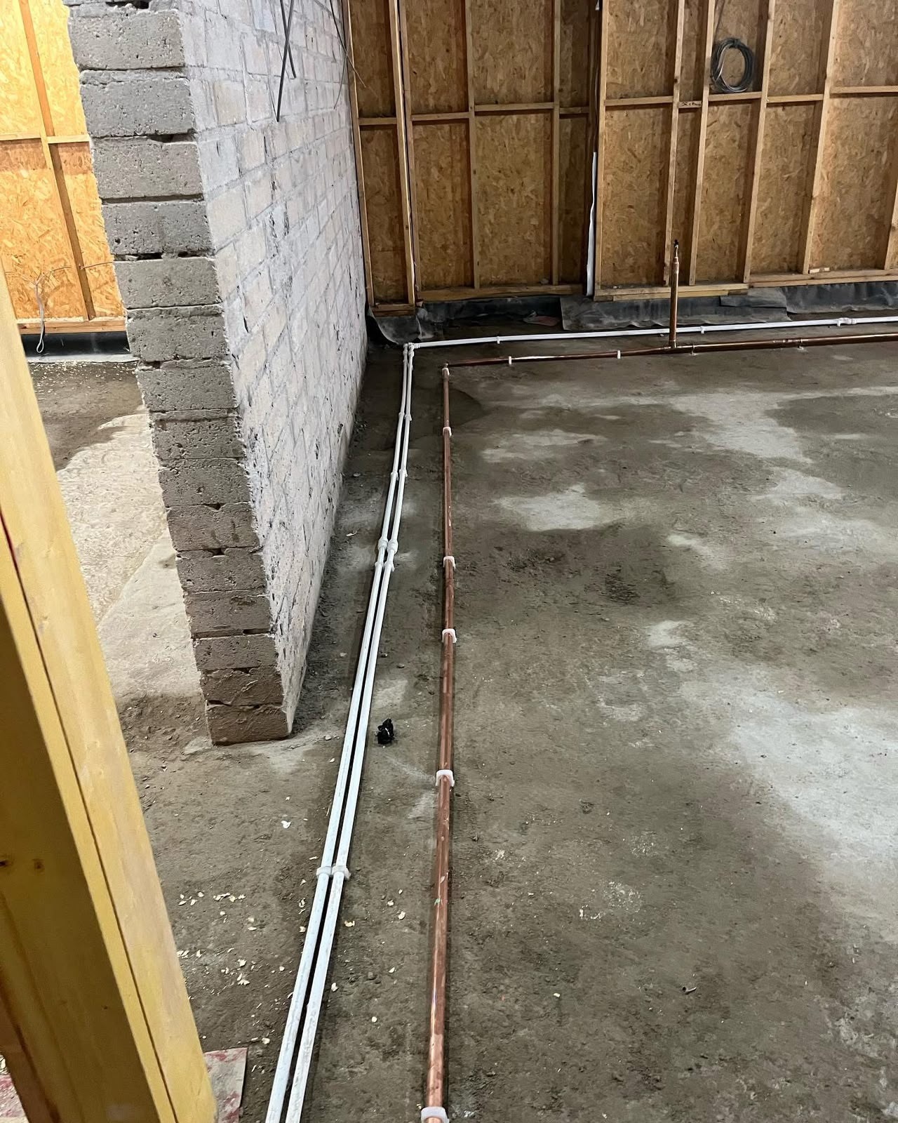 Copper and plastic first fix pipework laid across a commercial refurbishment floor