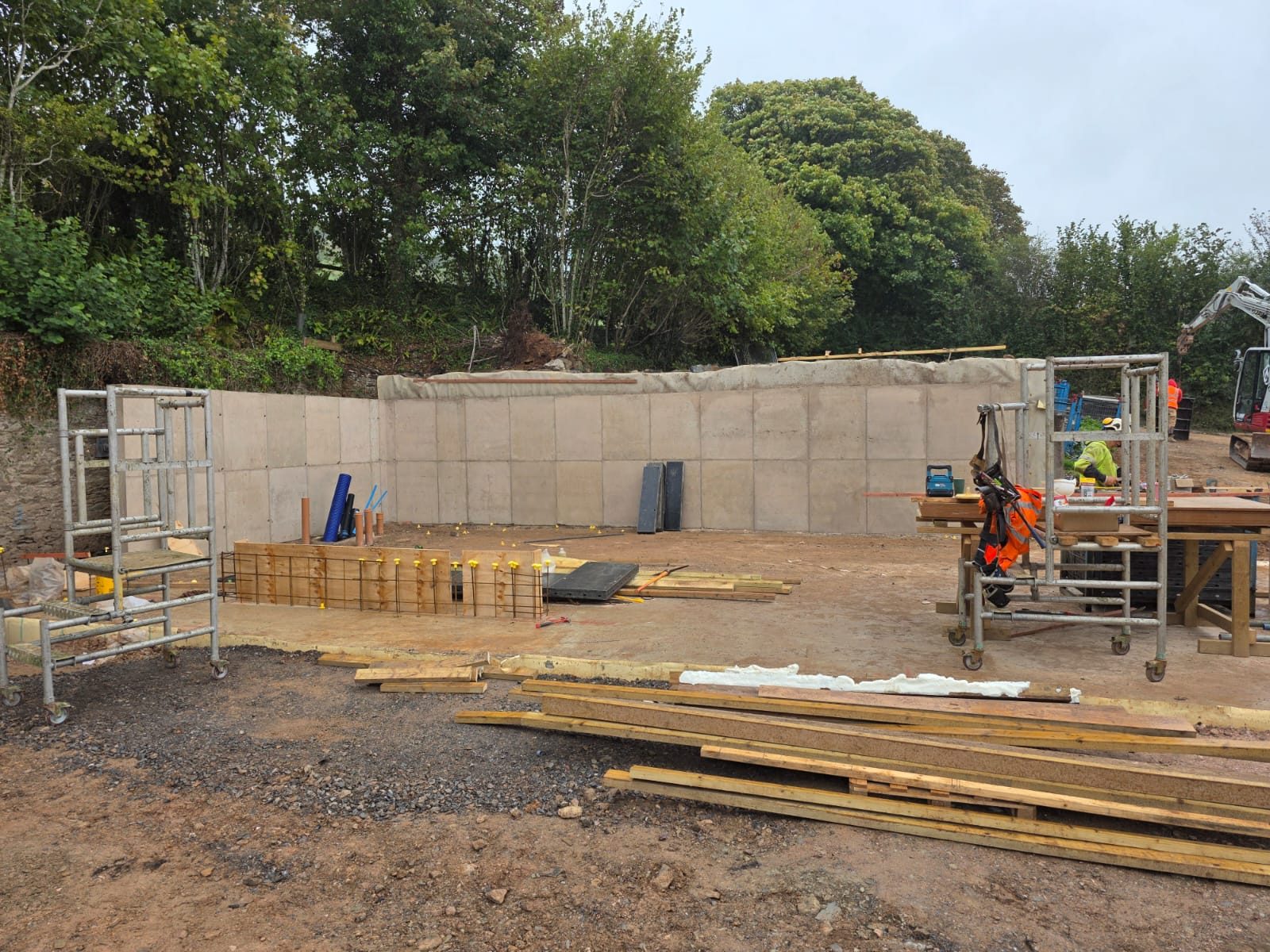 Reinforced concrete retaining wall by CC Construction Ltd: steel reinforcement, wall shuttering and poured concrete on a Cornwall site
