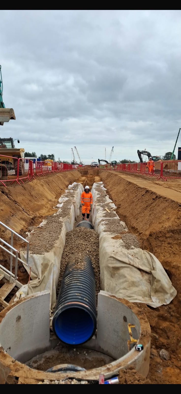 Large diameter drainage pipe being installed in a deep trench