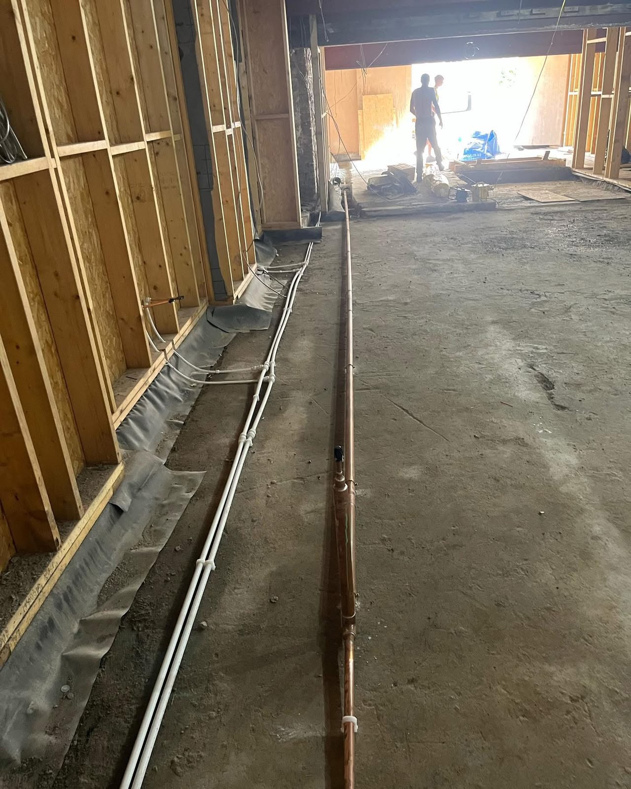 Plumbing pipework routed through a commercial refurbishment before flooring