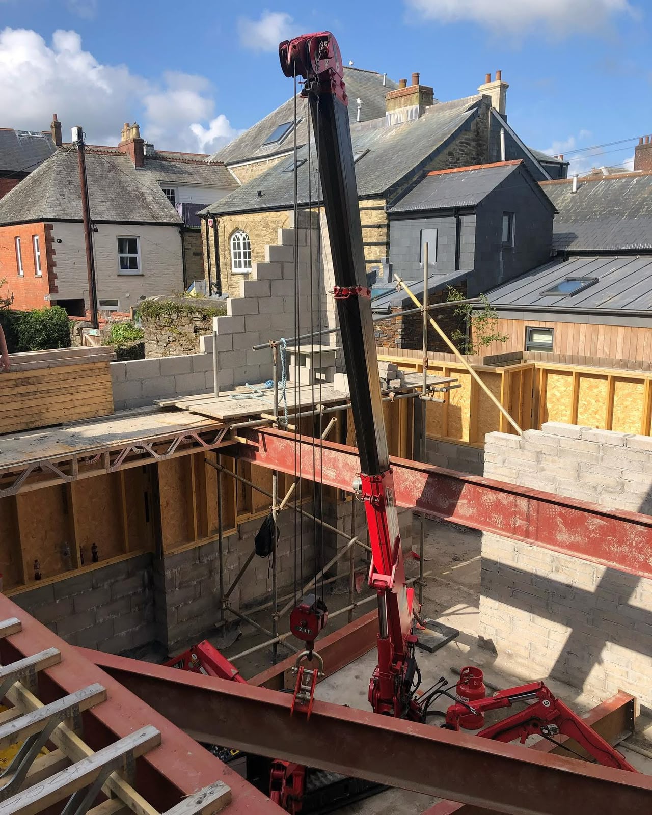 Structural steel beam being slung and lifted by spider crane on a Cornwall refurbishment