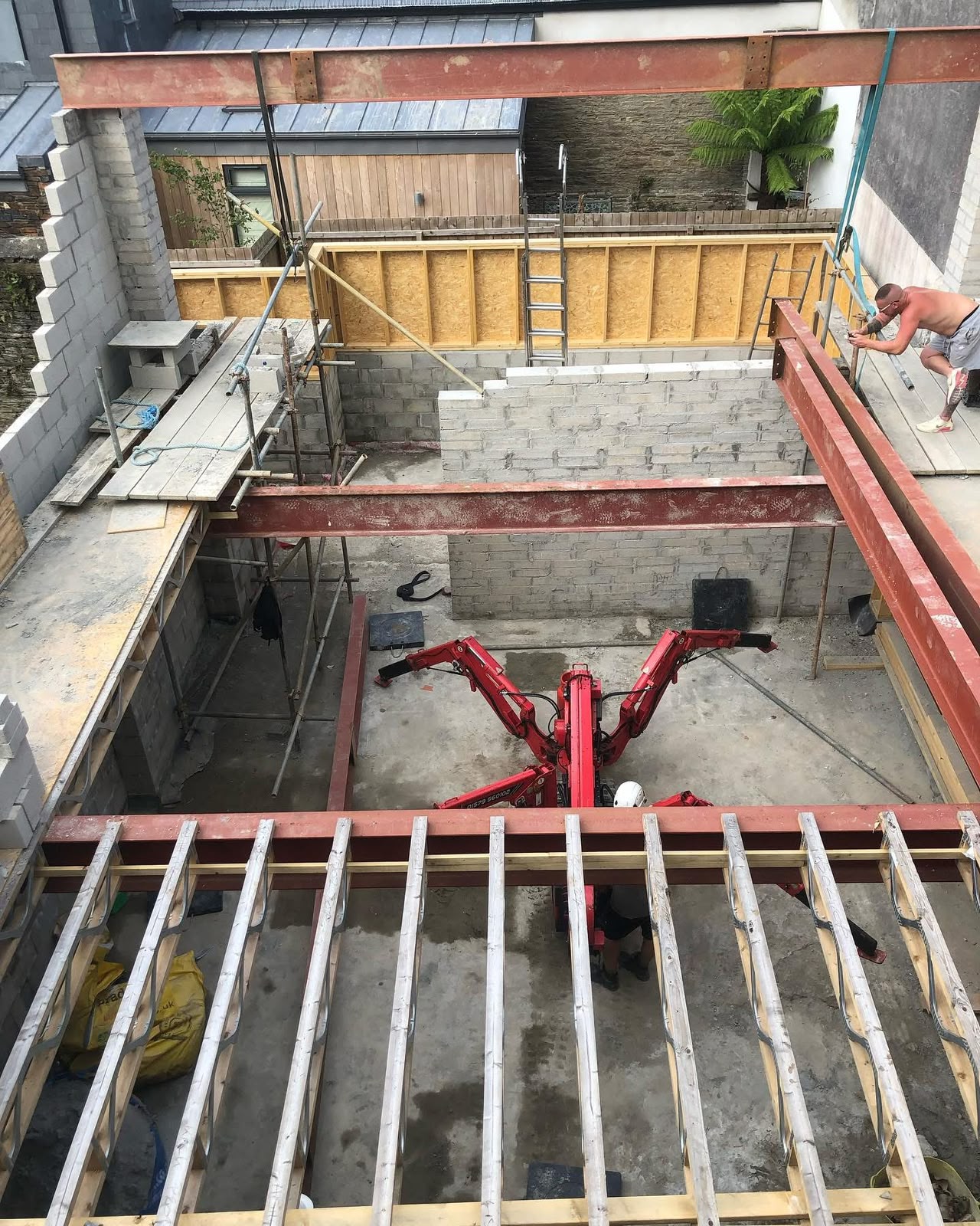 Steel beam grid and floor joists installed above block work walls on a refurbishment site